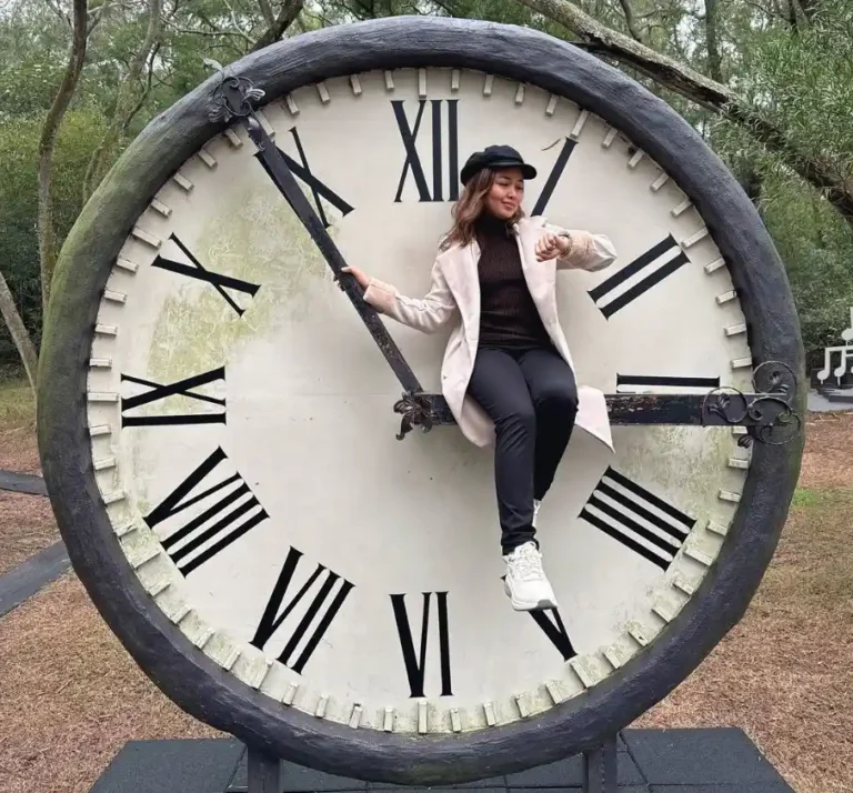 A person sitting on a big clock.